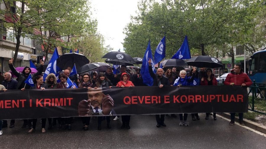 FOTO/ Reshje shiu gjatë protestës, qytetarët me çadra “Rama ik”