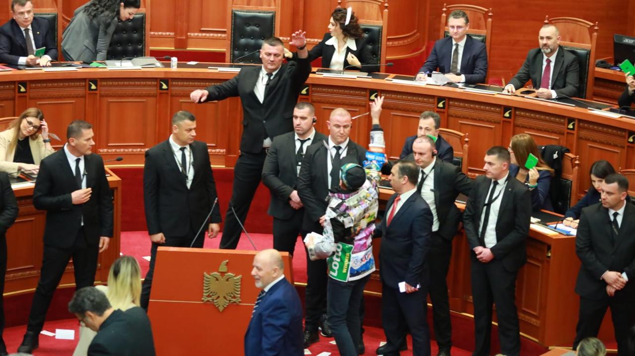 FOTOGALERI/ Deputeti Dashnor Sula  veshur me logo llotosh dhe dollarë, hedh tufa dollaresh mbi deputetët dhe ministrat socialistë